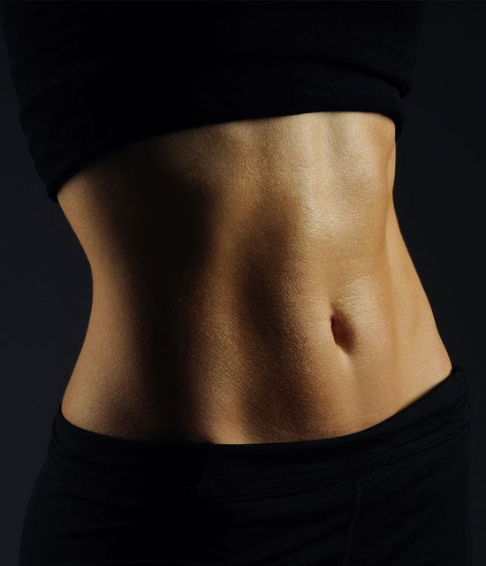 Close-up of a fit woman’s toned abdomen in black workout clothing, highlighting defined stomach and body contouring results