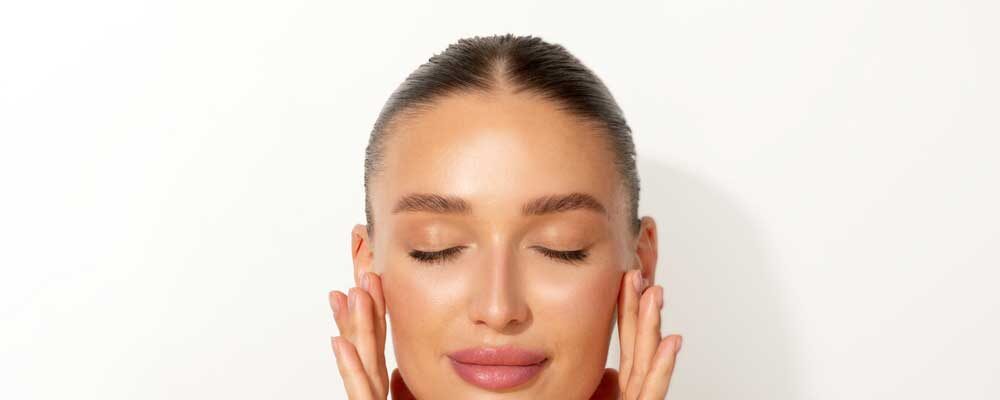 Woman Holding her face after laser treatment while closing her eyes