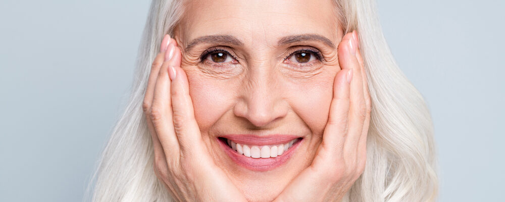 Women smiling holding her face