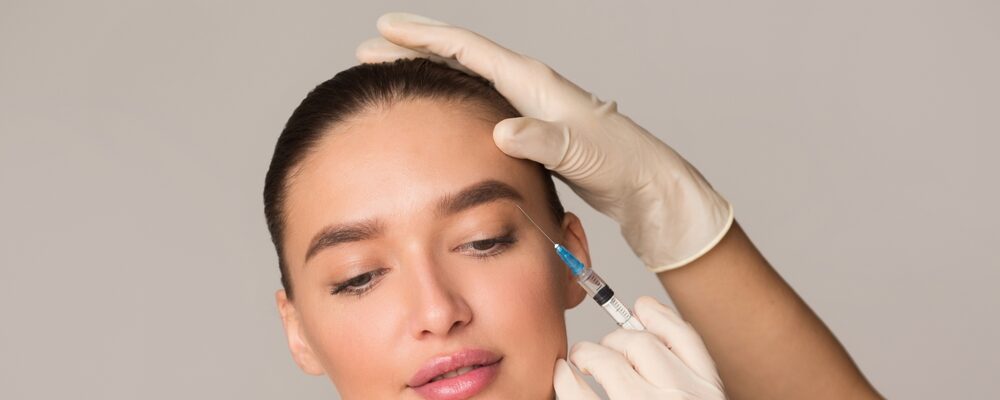 Women having Botox injected under her eyebrows