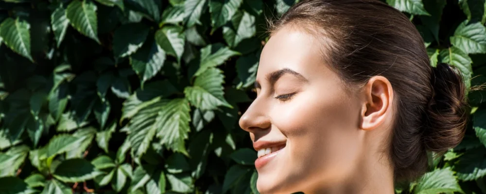 Woman applying sunscreen in soft morning light at home