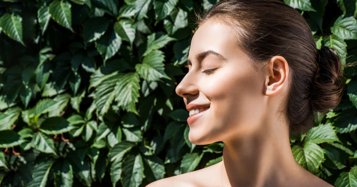 Woman applying sunscreen in soft morning light at home